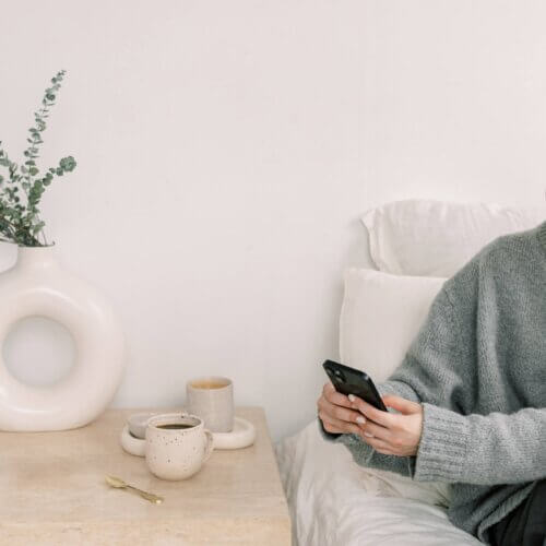 business owner reading phone in bed