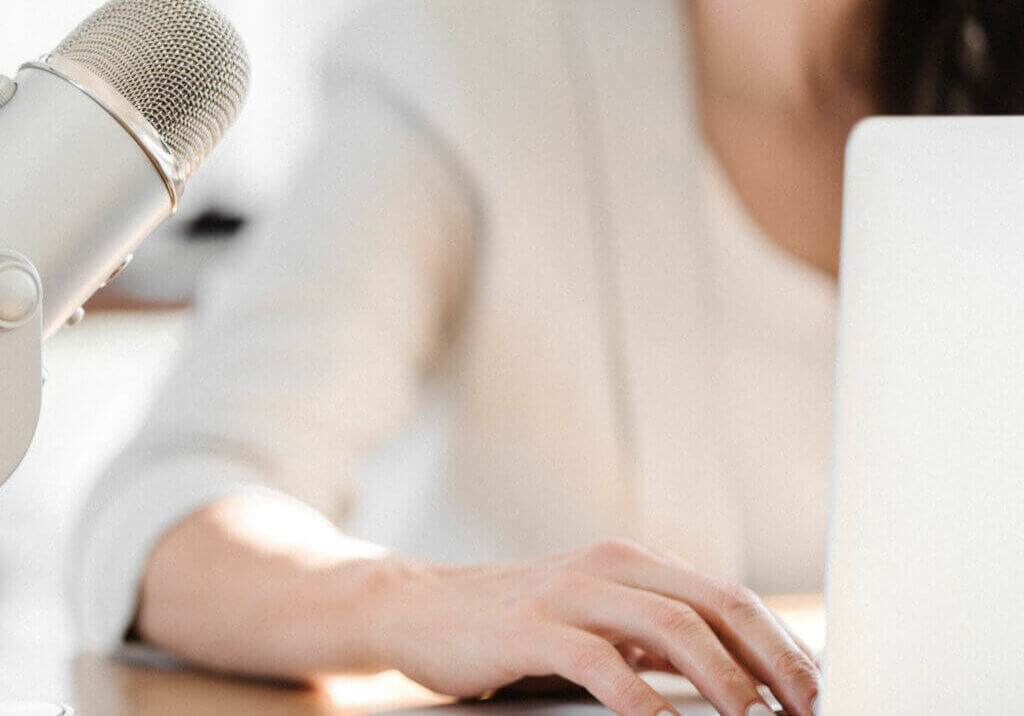 Business owner fixing broken links on wordpress website at desk next to a podcast mic.