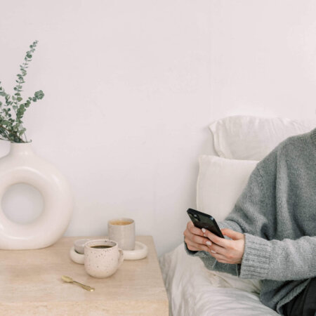 business owner reading phone in bed